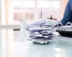 Person using calculator with stack of receipts in front of them