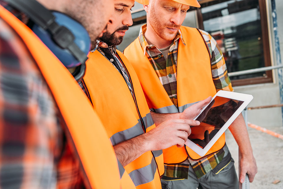 Construction workers gathering around an ipad 