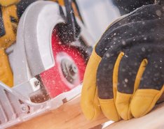 Gloved hands using power tool