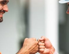 Two workers in vests and hard hats fist bumping