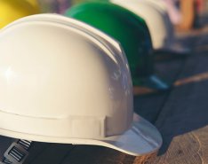 White hard hat in foreground surrounded by colorful hard hats