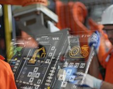 Two workers looking at hologram of technology with equipment icons